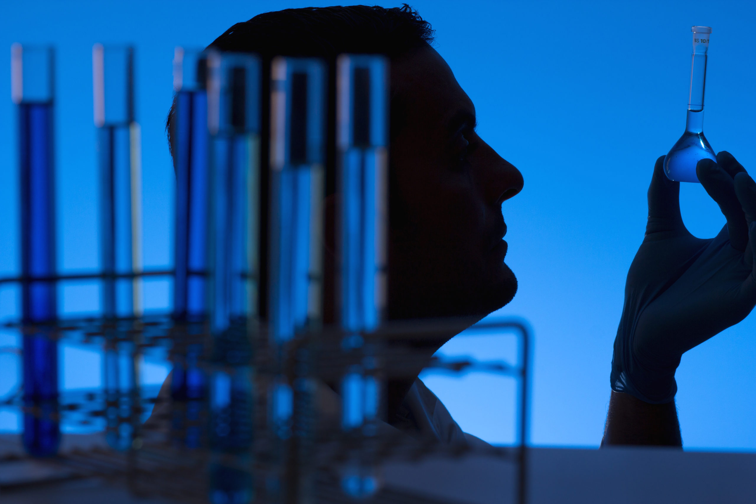 Researcher looking into a flask at the laboratory